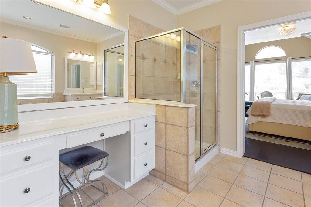 Experience luxury in the primary bathroom, featuring a stylish makeup vanity and a spacious shower.