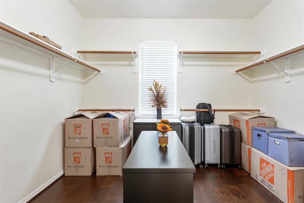 Expansive primary walk-in closet with natural light from a large window.