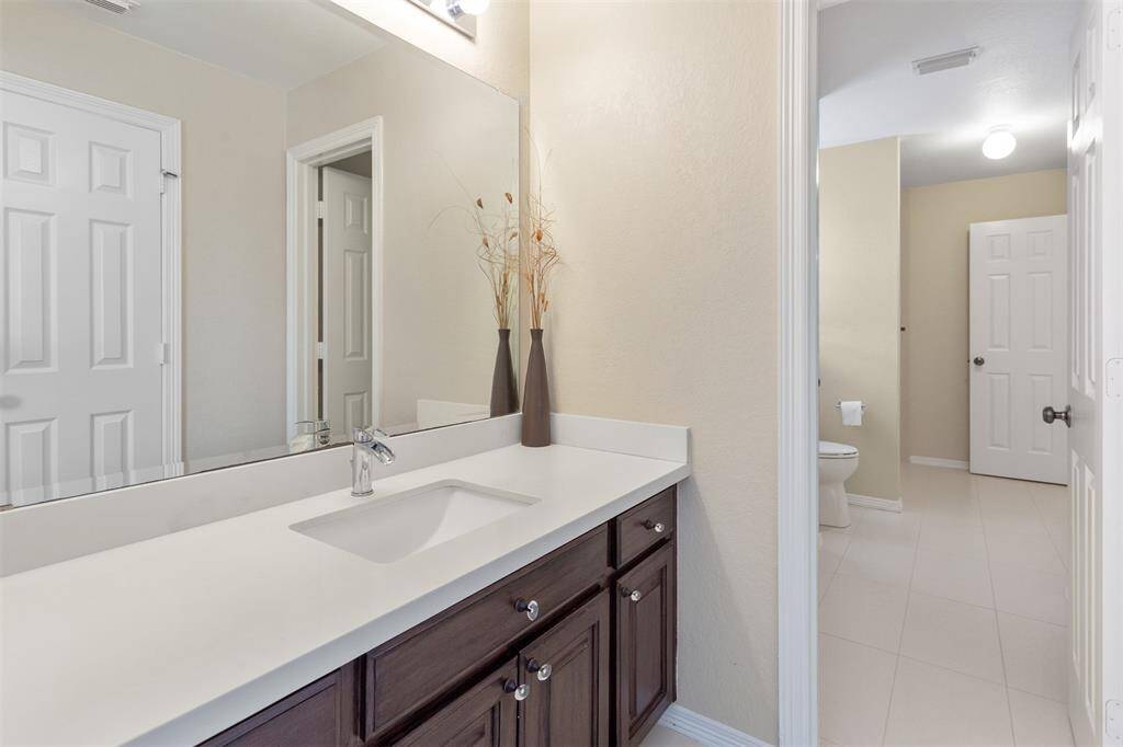 Modern second-floor Jack and Jill bathroom with sleek vanity and abundant natural light.