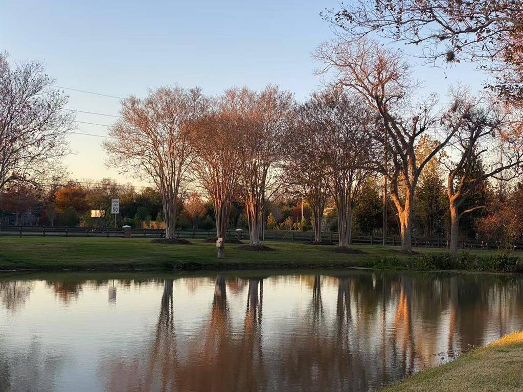 Experience serene autumn beauty with this picturesque view of trees reflecting on a tranquil pond. Perfect for peaceful, scenic living.