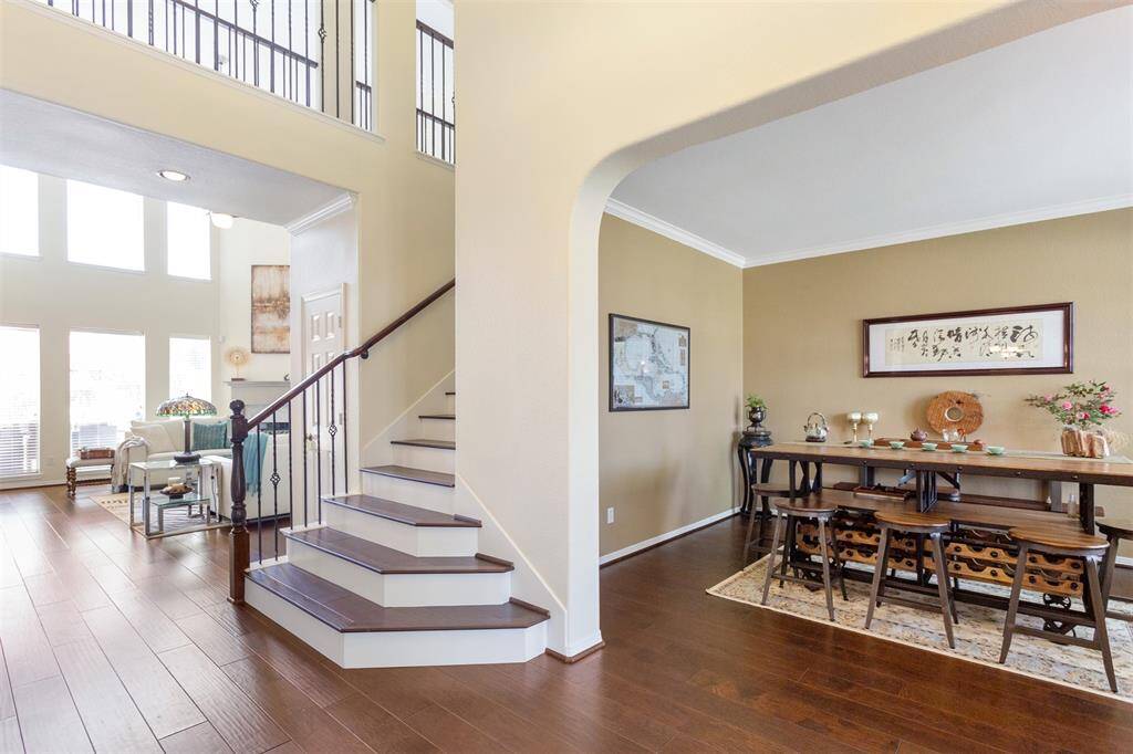Elegant wood flooring graces the entire first floor and stairs, complemented by stylish wrought iron railings.