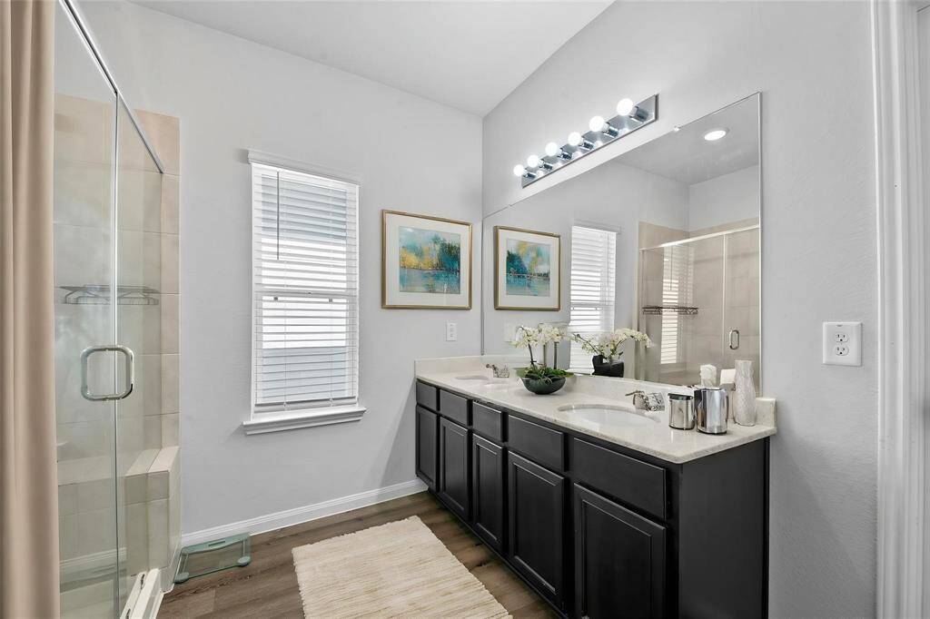 The ensuite features a dual-sink vanity, a large shower, and a private water closet and spacious walk-in closet. Designed for both style and functionality, this well-appointed space provides plenty of room to relax and refresh.