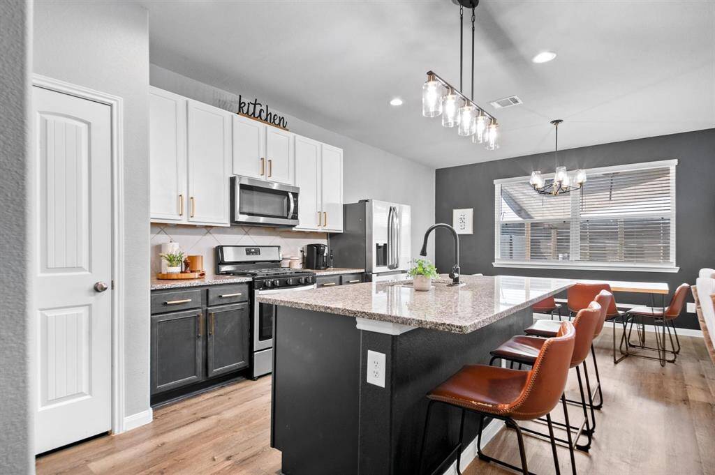 The kitchen boasts sleek granite countertops, stainless steel appliances, and a convenient breakfast bar, perfect for casual dining and entertaining.