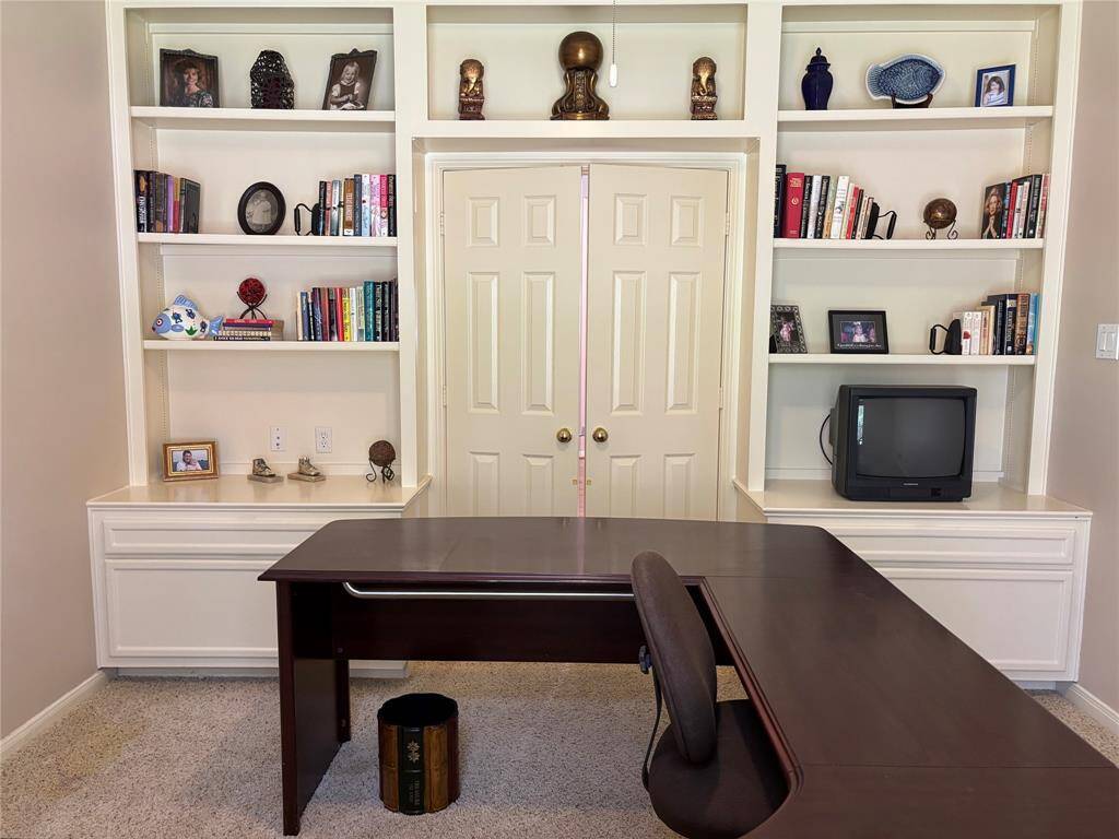 Spacious office featuring extensive shelving and ample storage drawers.