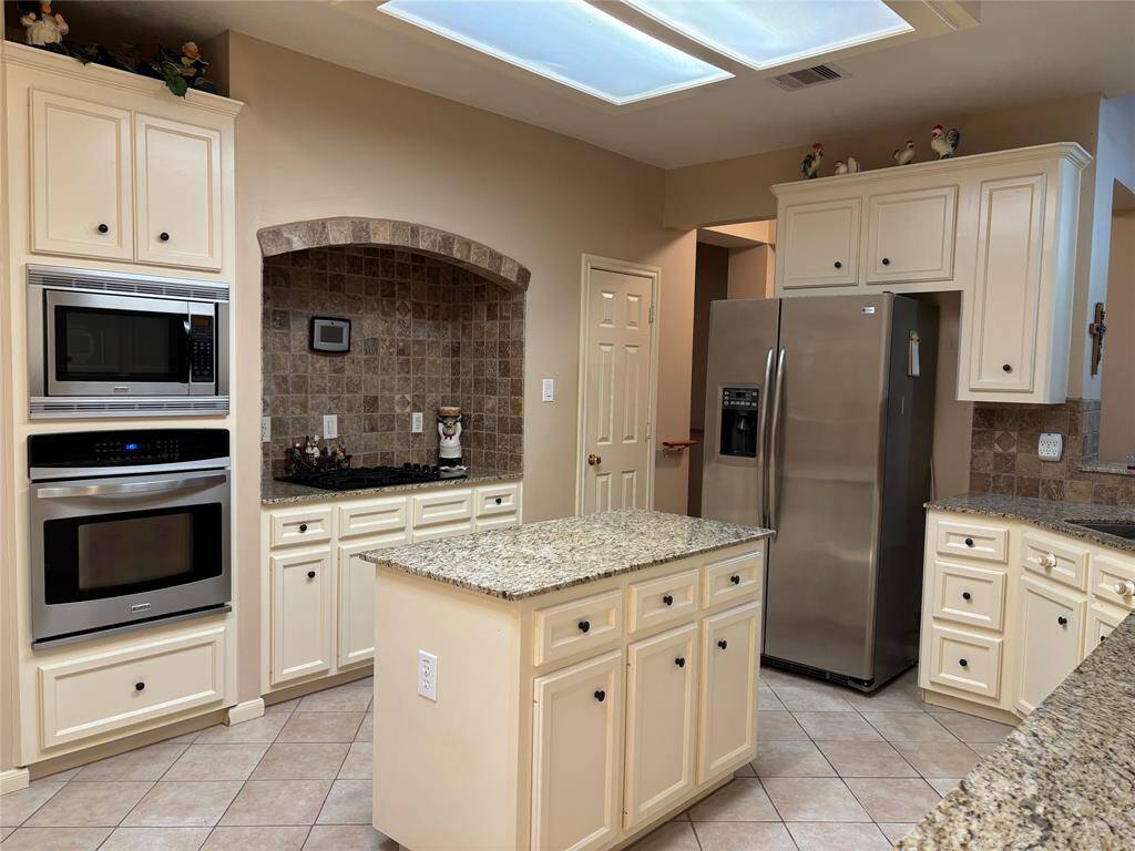 Spacious kitchen featuring granite countertops, stainless steel appliances, and an abundance of drawers and cabinets. The refrigerator is included.