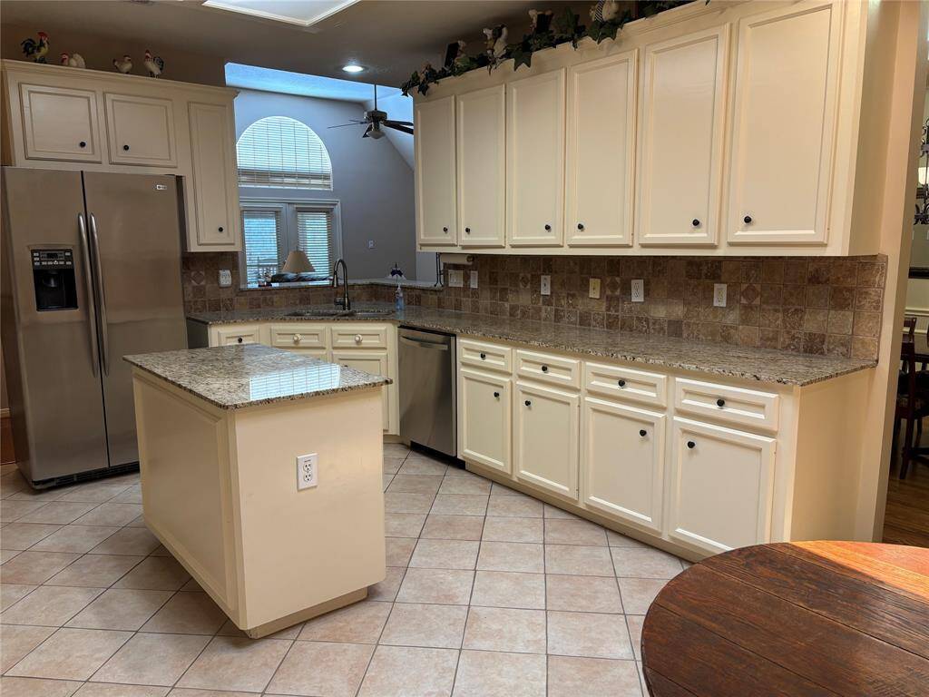 The kitchen also features a central island with more storage and work space.