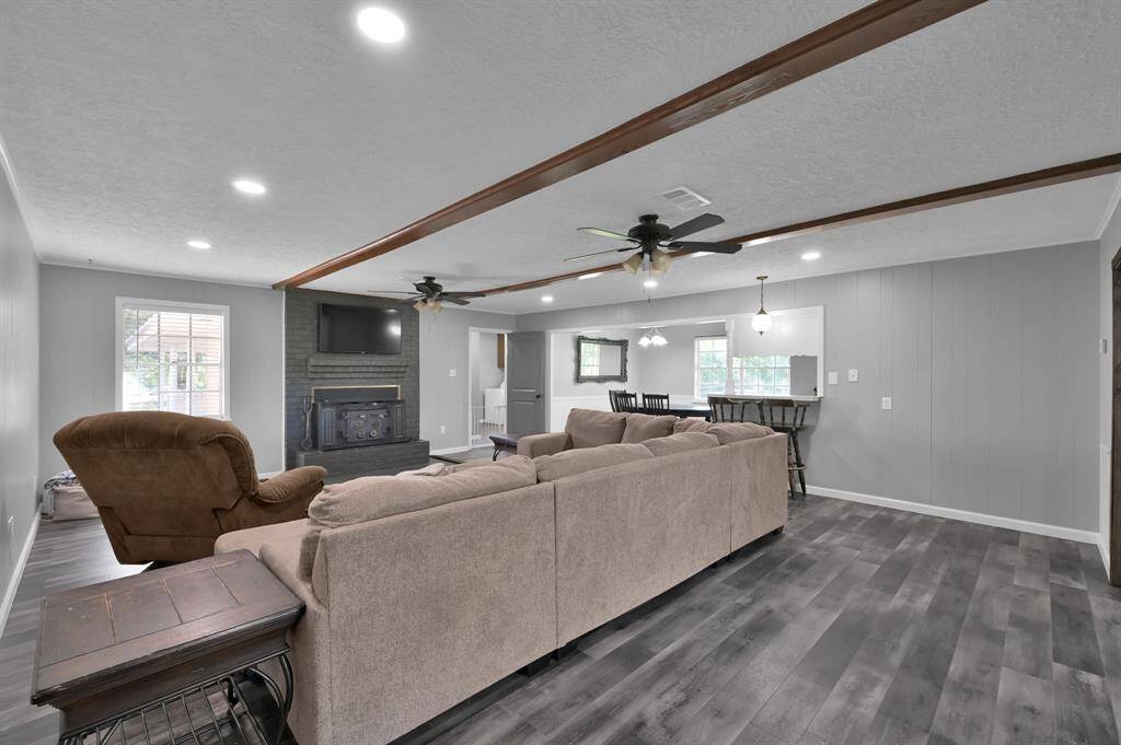 Newer recessed lighting, wood burning fireplace, and exposed beams