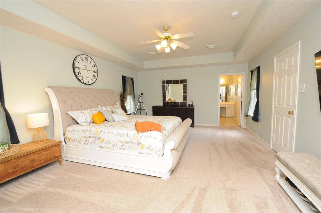 Primary suite with high tray ceilings and plenty of open space, creating a sense of calm and relaxation.