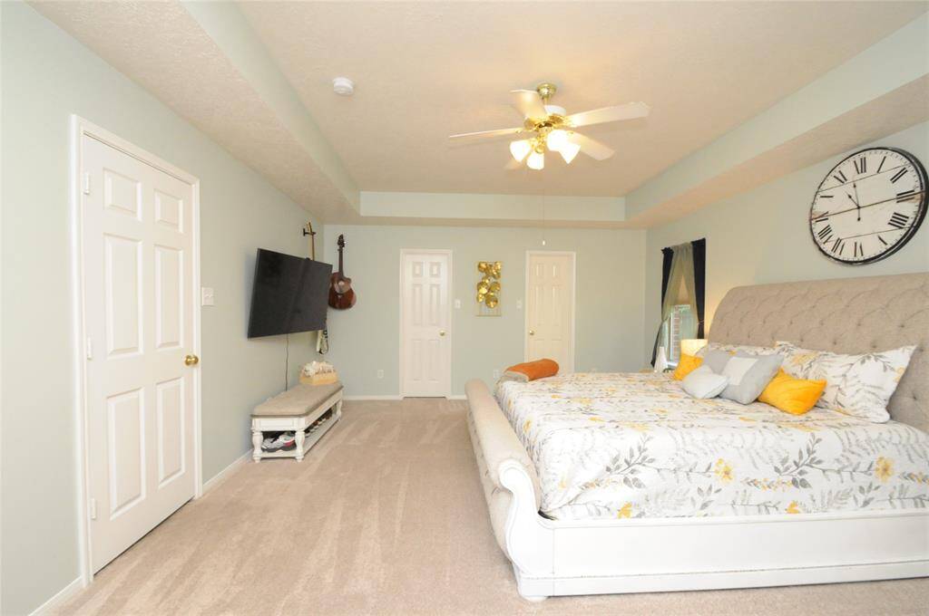 This spacious primary bedroom that feels like a personal sanctuary and features his and her closets