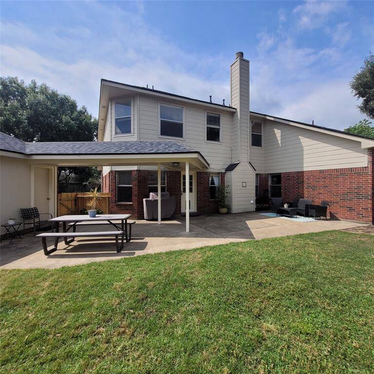 Back of home with covered walk way from the house to the 3 car garage
