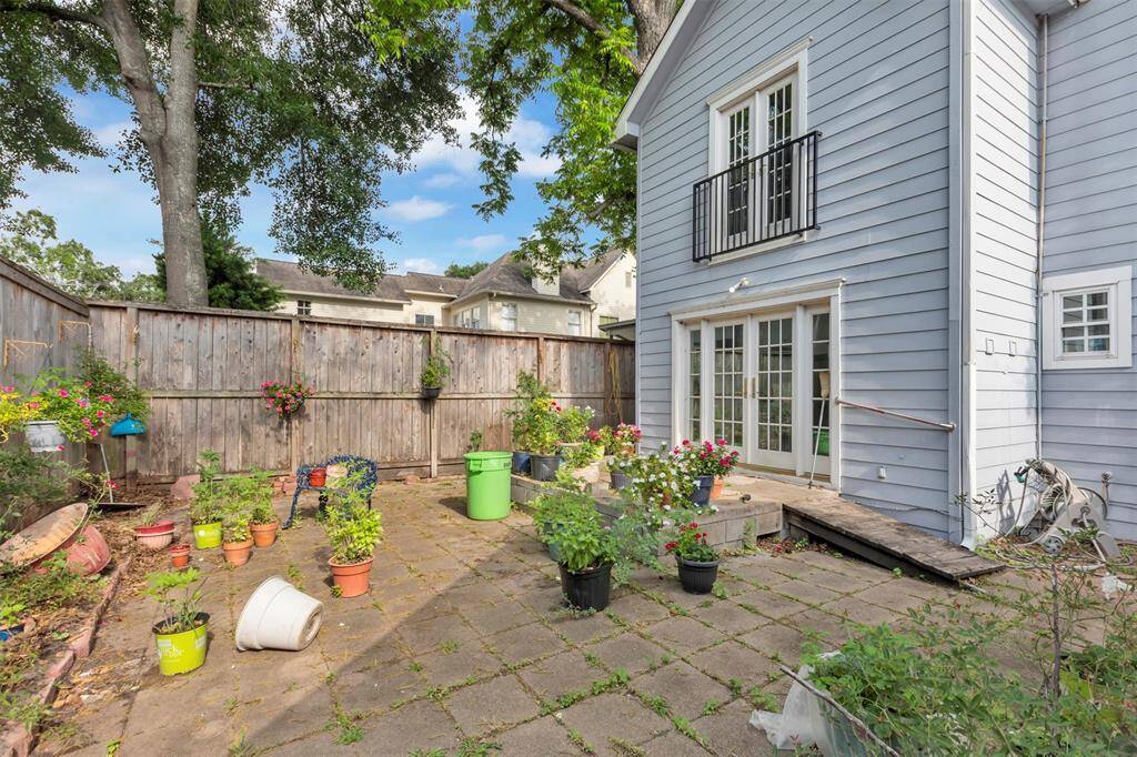 Private backyard patio enclosed by a tall wooden fence—ideal for relaxing or entertaining in a secure outdoor space.