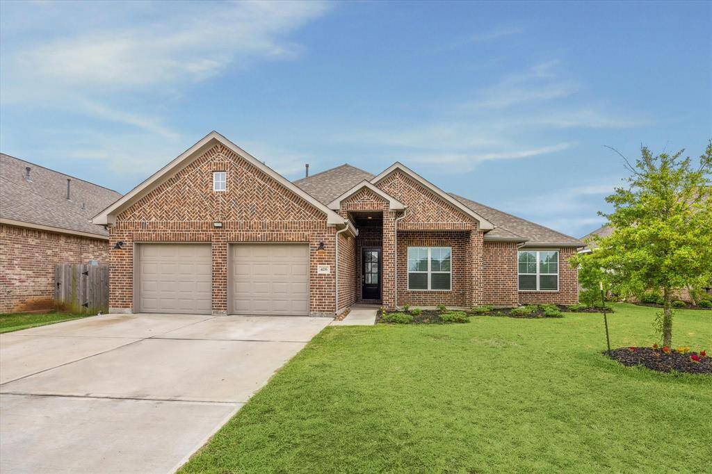 This is a charming, single-story brick home featuring a two-car garage. It has a well-maintained lawn and a welcoming front entrance, providing great curb appeal in a suburban setting.