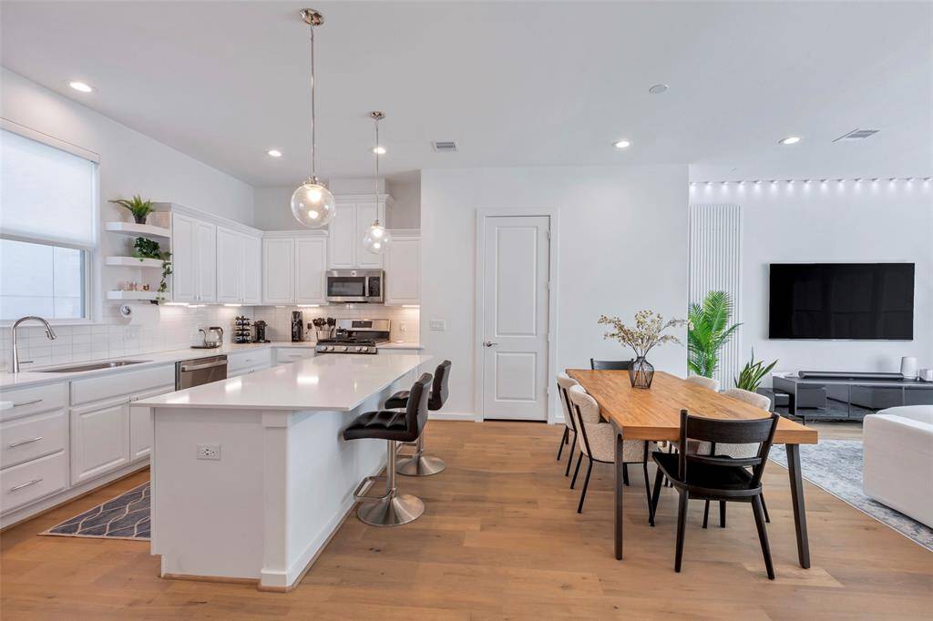 Nestled between the kitchen and living room, the dining area offers a perfect space for meals, with the pantry conveniently tucked behind the closed door for extra storage.