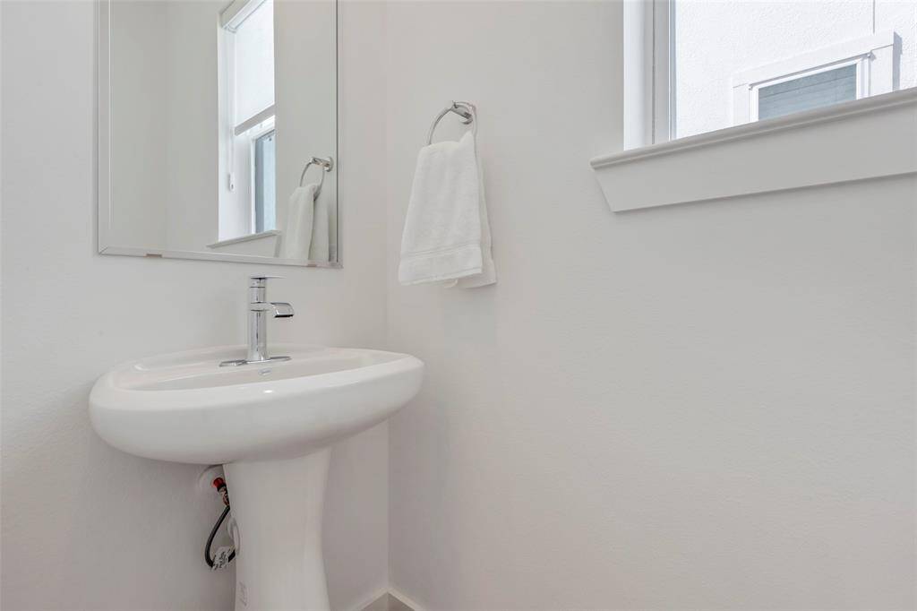 The half bath on the second floor features clean, modern finishes, offering both convenience and style for guests or everyday use.