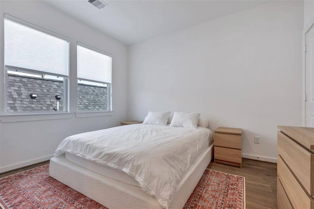 This secondary bedroom on the third floor is filled with natural light from large glass windows, offering a bright and airy space. Imagine the possibilities as you design it to match your personal style!