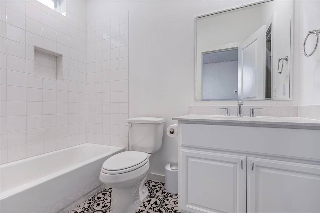 The first-floor bathroom features a clean tub and shower combo, offering convenience and comfort—plus, a walk-in closet just out of view adds extra storage space.