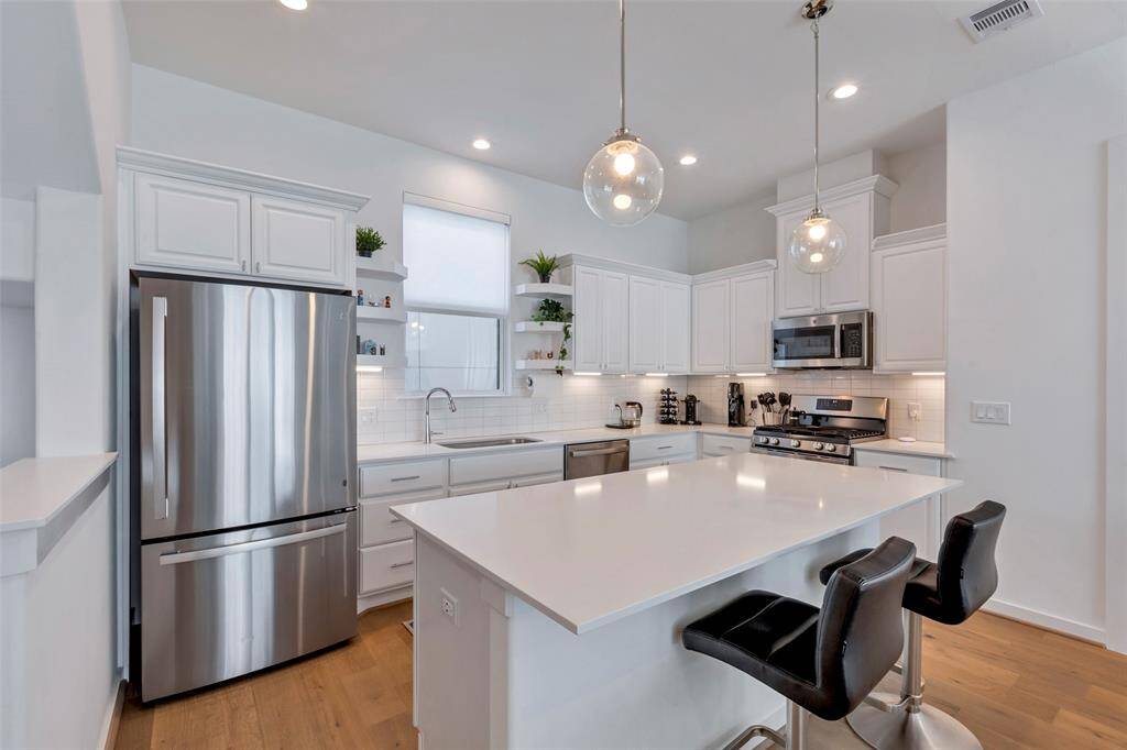 The kitchen features a spacious island—perfect for prepping, serving, or gathering, offering a sleek and versatile workspace.