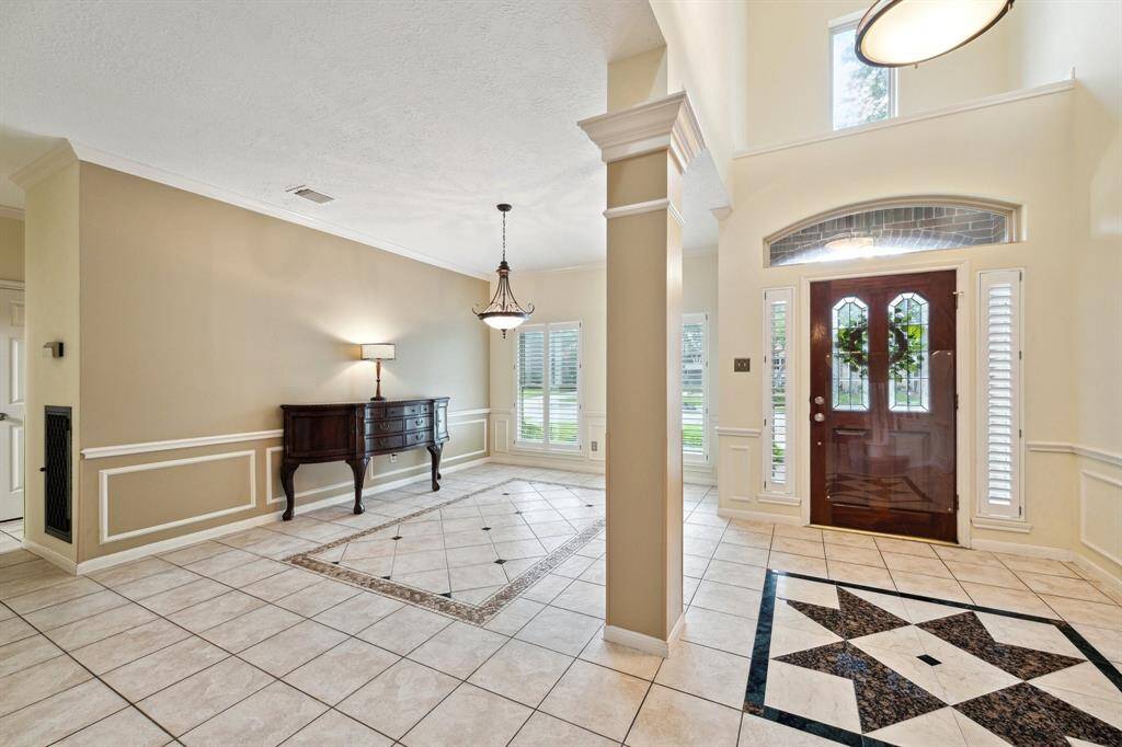 ENTER INTO THIS GORGEOUS HOME THROUGH THE STORM DOOR AND BEAUTIFUL GLASS PANE DOOR. THE GRAND ENTRY OFFERS DECORATIVE MOLDING AND GRANITE FLOORING DETAIL IN BOTH THE ENTRY AND FORMAL DINING.