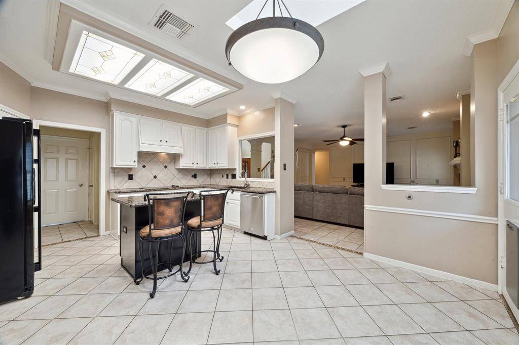 THE SPACIOUS BREAKFAST ROOM AREA OFFERS PLENTY OF SEATING AND VIEWS TO THE BACK YARD AND SUN ROOM