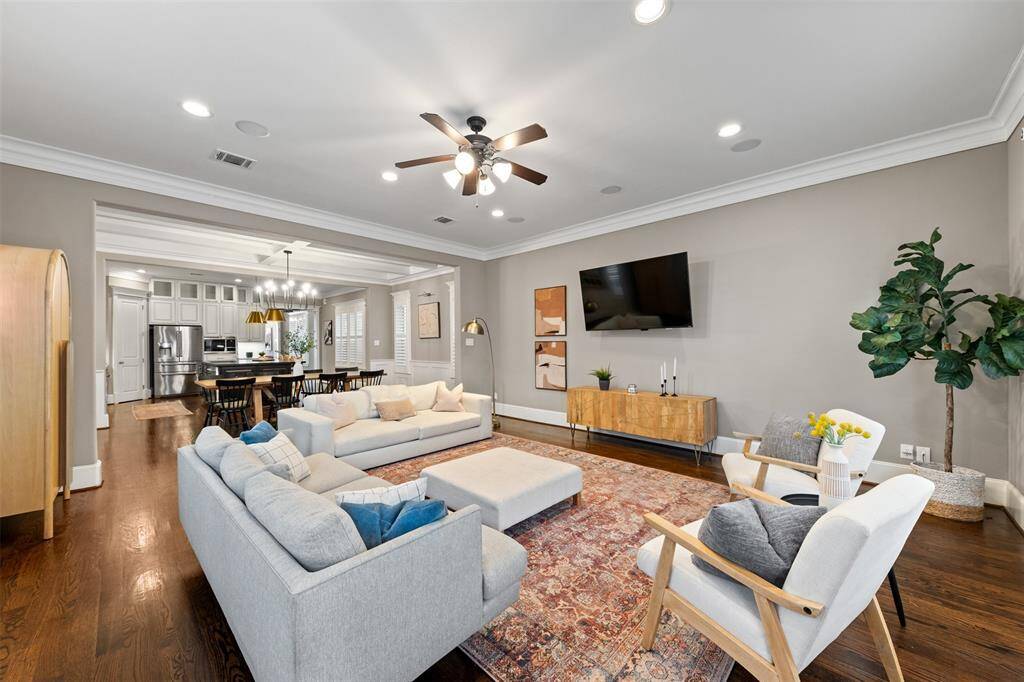 Enjoy elevated comfort in the open-concept living area, where high ceilings, crown molding, and wide-plank hardwoods create a warm, welcoming atmosphere.
