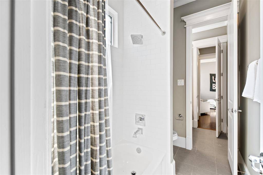 Classic white subway tile with polished nickle finishes give a clean look to these shower/tub.