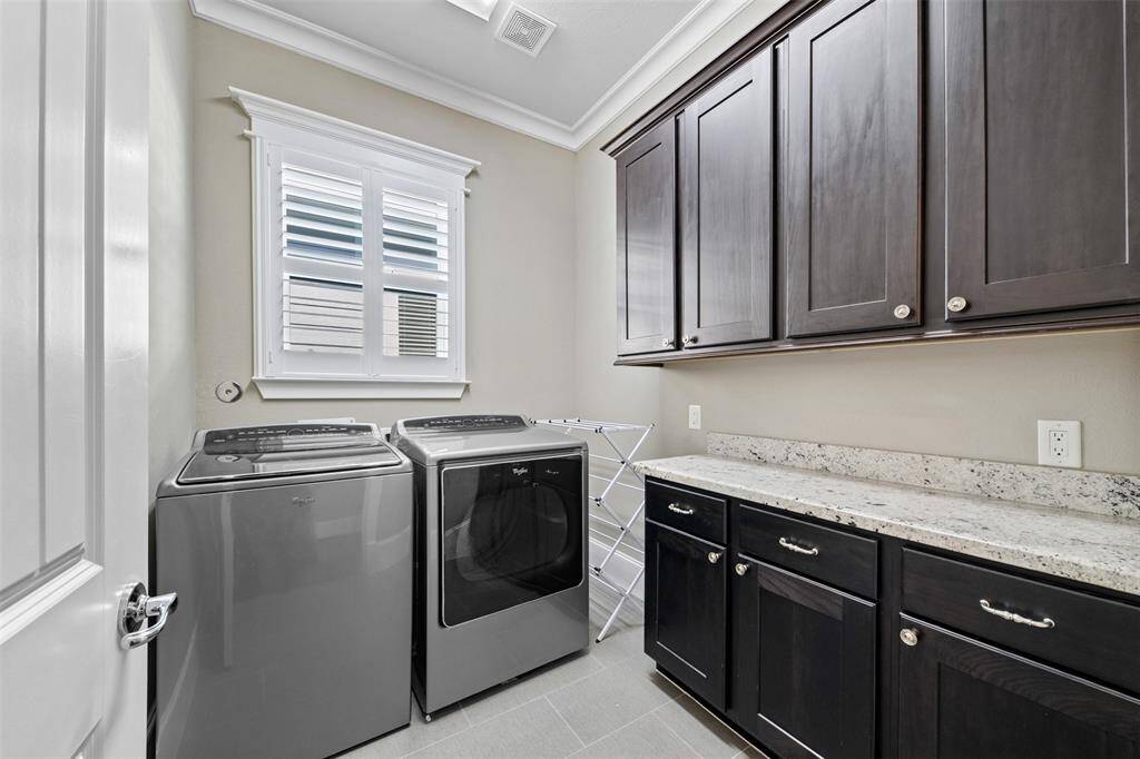 Conveniently located upstairs, the utility room features built-in storage, tile flooring, and easy access to all bedrooms for everyday efficiency.