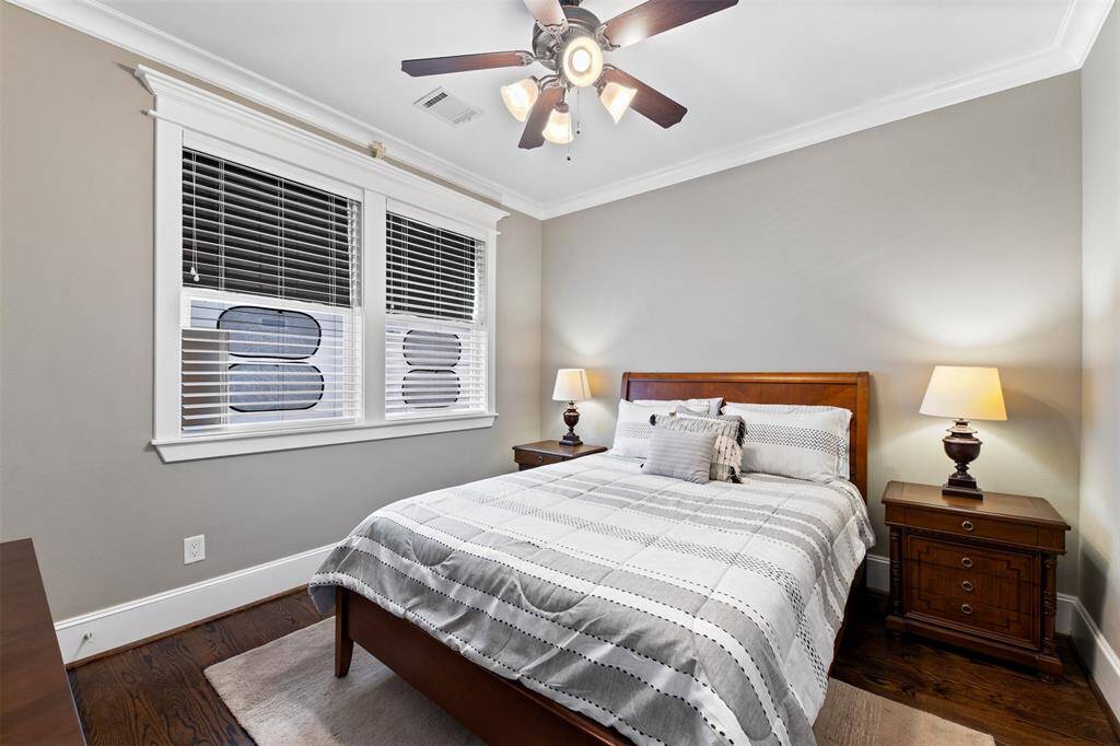 No detail overlooked — these secondary bedrooms feature plantation shutters, crown molding, and hardwood floors throughout.