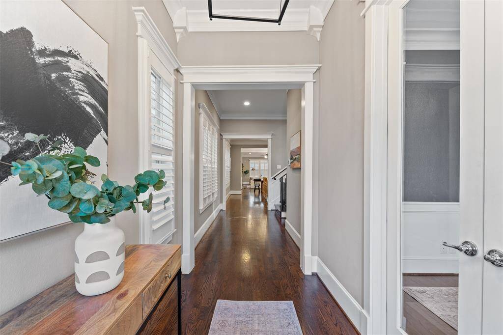 Soaring ceilings, detailed crown molding, and rich hardwood floors create a sense of space and sophistication throughout the home.