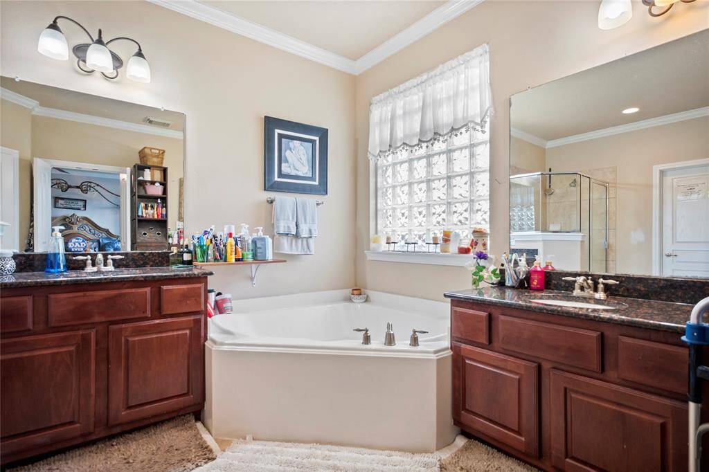 Indulge in everyday luxury in this elegantly designed primary bathroom, featuring a deep soaking tub perfect for unwinding after a long day.Enjoy the best of both worlds with a separate walk-in shower