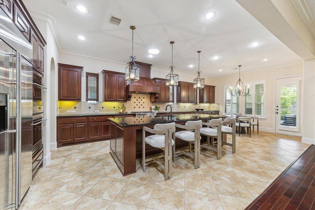 Bevolo lighting continues over the expansive island and breakfast nook.