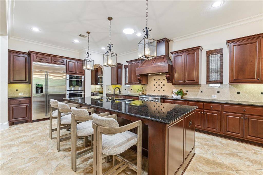 Monogram built-in fridge, double ovens, commercial 6 burner gas cooktop and handsome vent hood are the chef's kiss. The microwave is around the corner in the butlers pantry.