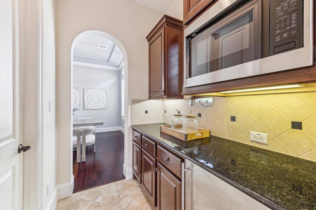 Butler's pantry houses the microwave, beverage fridge, along with plenty of storage and counter space. Large walk-in pantry is to thru the left door.