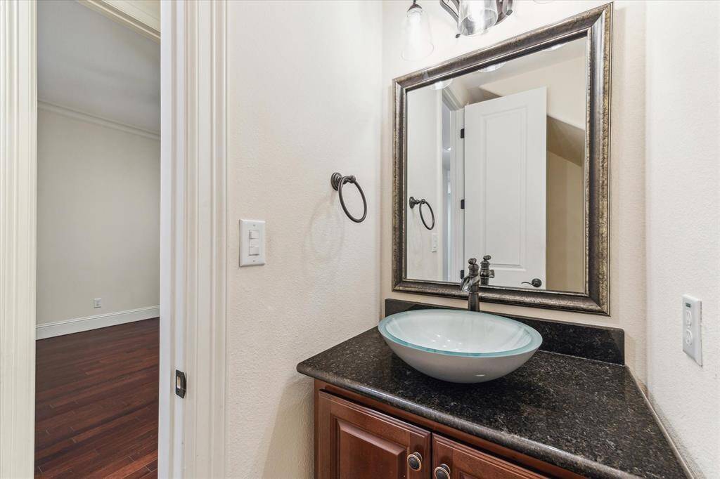 There are 2 powder baths in this home... one downstairs and one upstairs.... framed mirror and vessel sink are lovely touches.
