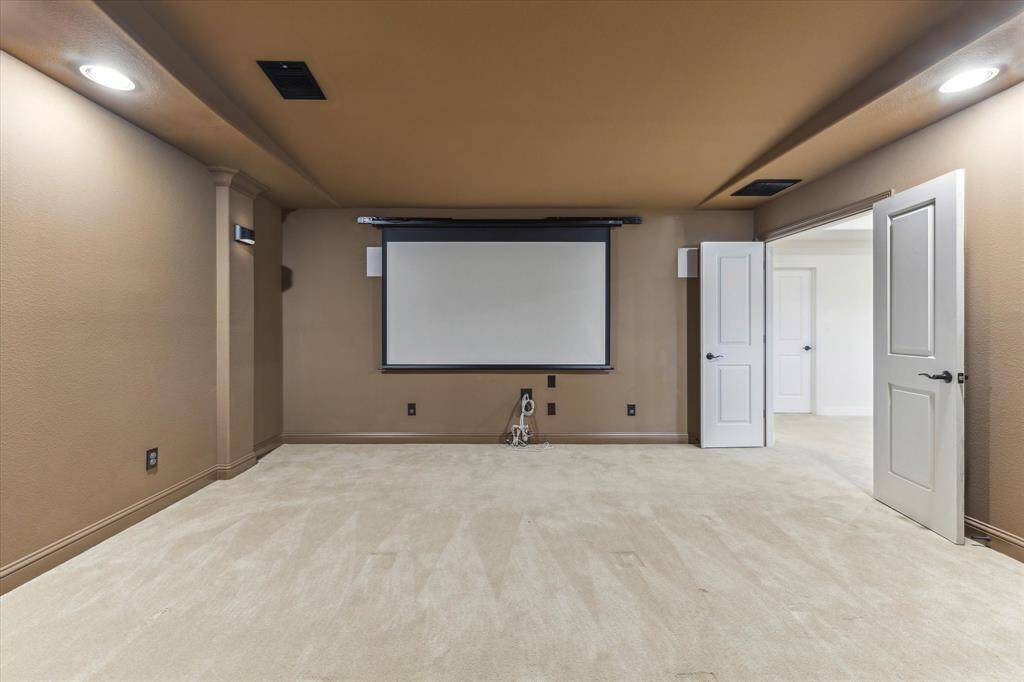 Media room is designed for the ultimate cinematic experience with a large screen and projector, dimming wall sconces for movie mode and mood lighting, and a full speaker system that brings every scene to life.