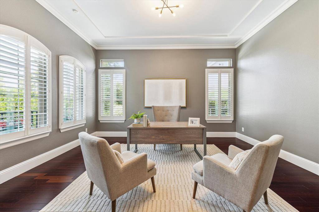 Bright windows cased with wood shutters and a neutral color pallet provide a peaceful and pretty space to work.
