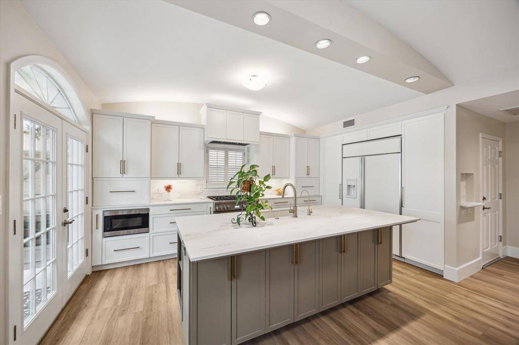 Recently renovated kitchen features shaker-style cabinetry and on each end of the counters are lift up "garage" doors over spaces for small appliances