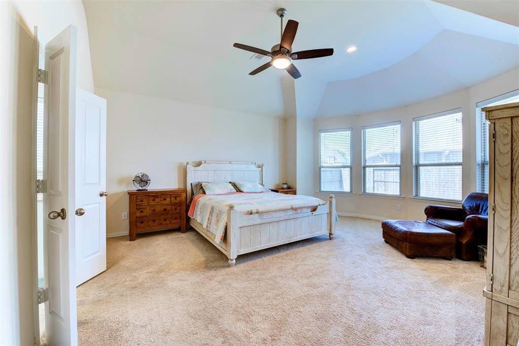 Spacious Master Bedroom with vaulted ceilings, natural light from large windows, and room for a sitting area. Perfect for comfort and relaxation