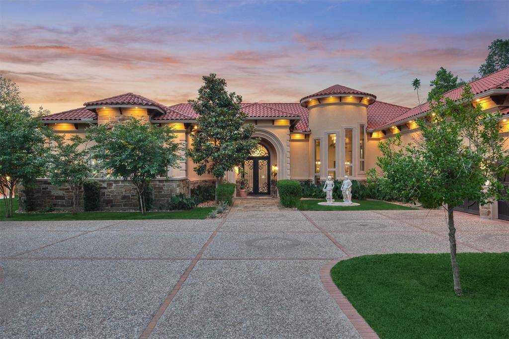 Italian-inspired architecture welcomes you to this lakefront estate in Ridgelake Shores—featuring a clay tile roof, gated entry, and mature landscaping on over 2 acres of prime lakefront property