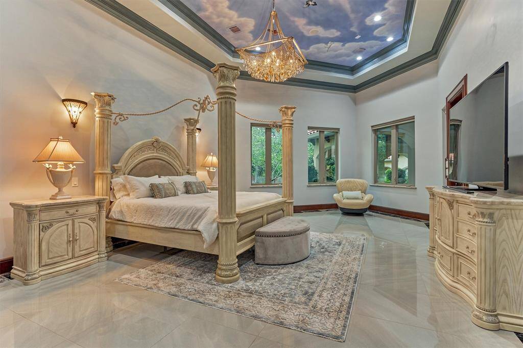 Luxurious primary suite featuring an Italian hand-painted ceiling and dramatic tray design.