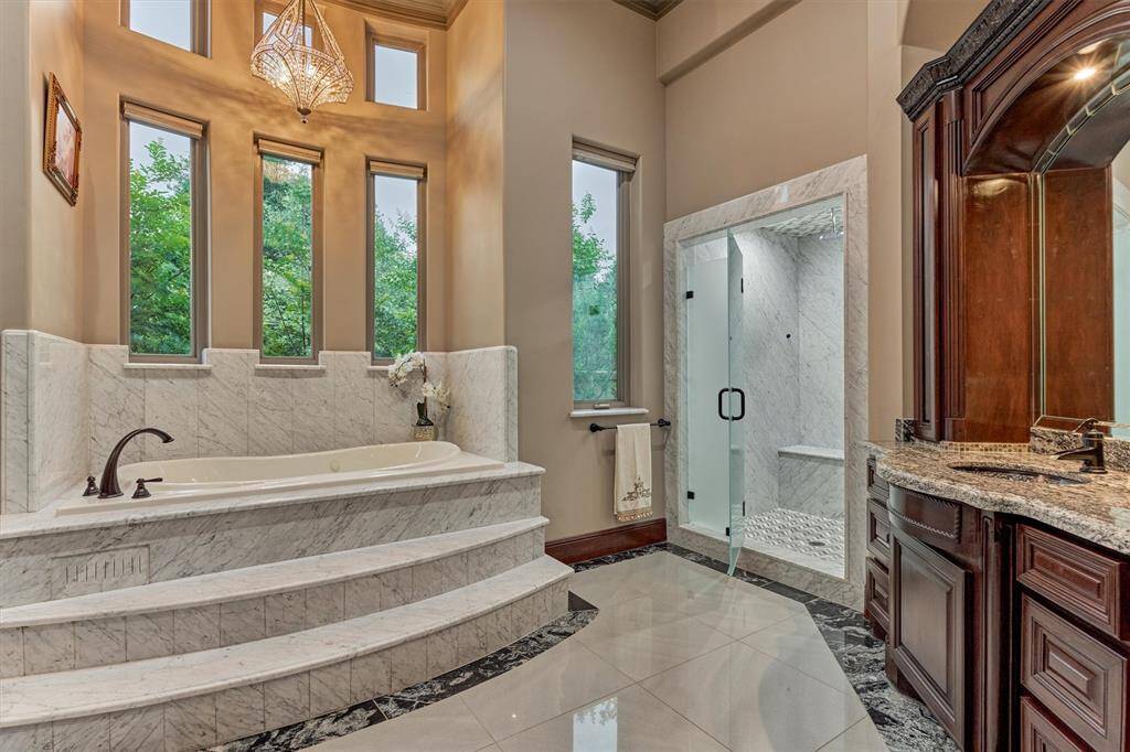 Opulent bath retreat with grand columns, raised soaking tub, and custom tilework.