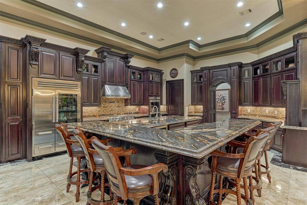 Chef’s dream kitchen with gas cooktop, double electric ovens, and elegant Italian-style finishes.