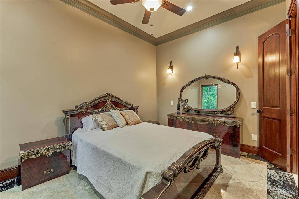 Elegant secondary bedroom with warm finishes and custom touches, connected by a shared Hollywood-style bath.