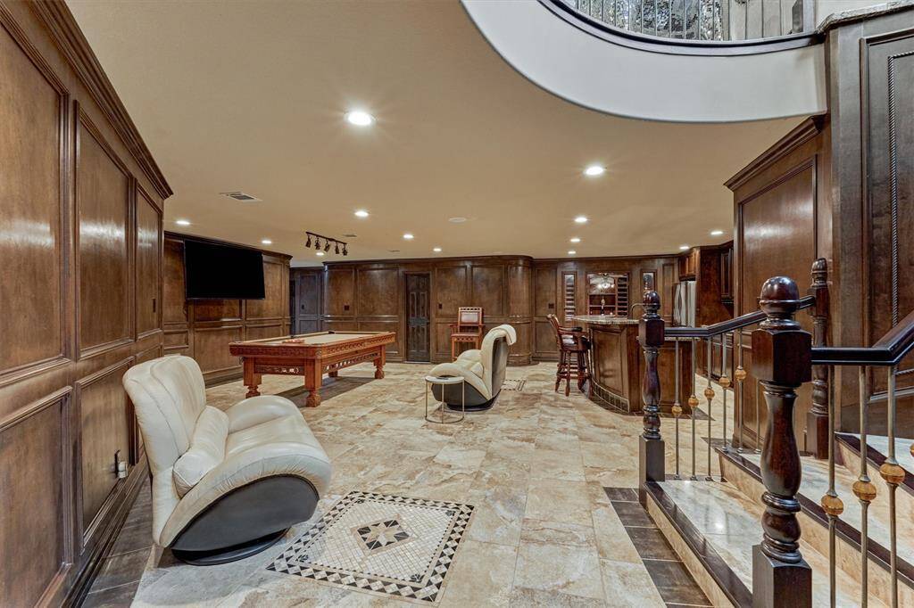 Spacious game room with billiards area downstairs, perfect for hosting and family fun.