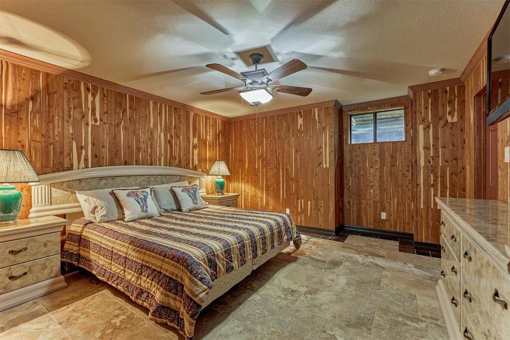Warm cedar-paneled downstairs bedroom offers privacy, comfort, and a unique rustic charm.