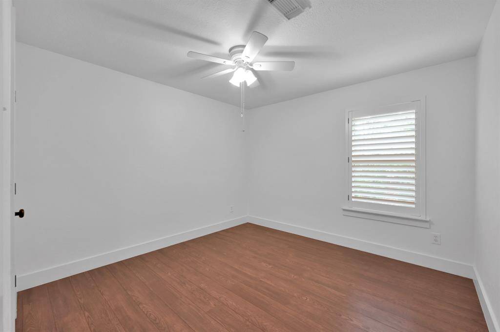 The first secondary bedroom upstairs has a generous closet & window with plantation shutters.