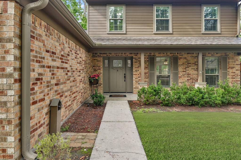 The front entry has a charming brick exterior, fresh landscaping, and a cozy covered porch that invites you home.