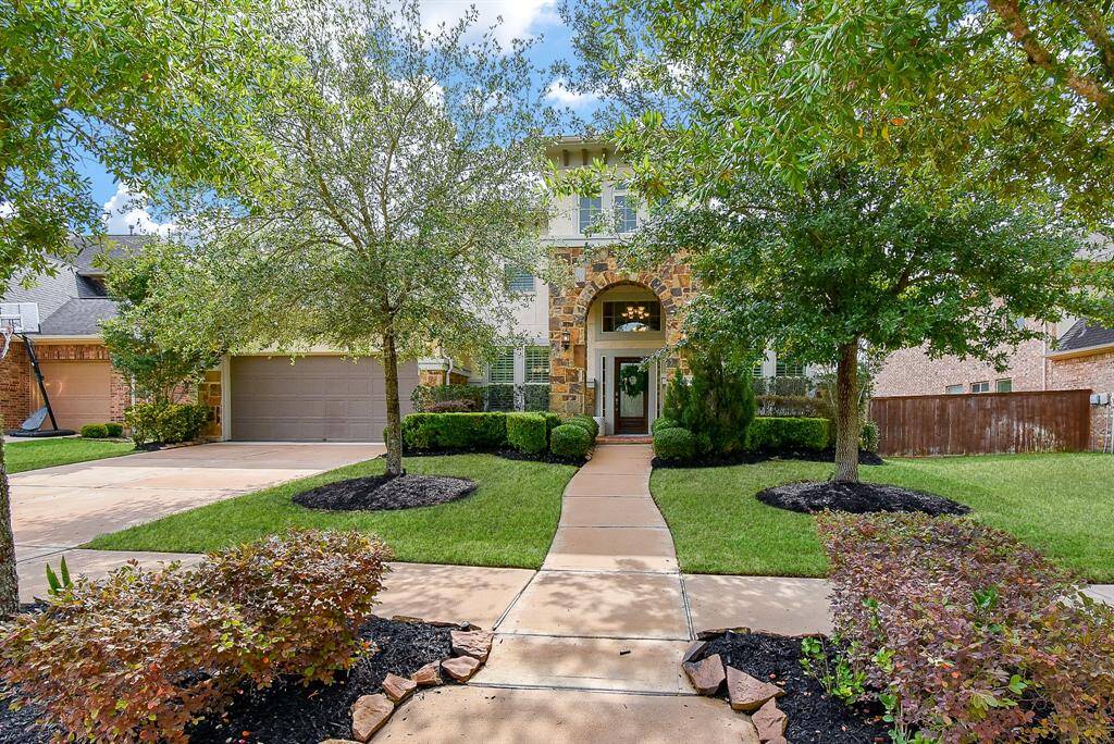 Shade from the sun & Custom landscaping. A win-win for this stunning exterior!