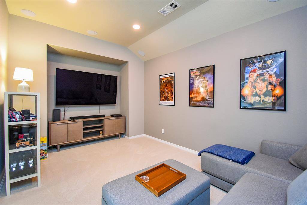 Home theater/media room connects to game room with barn doors.