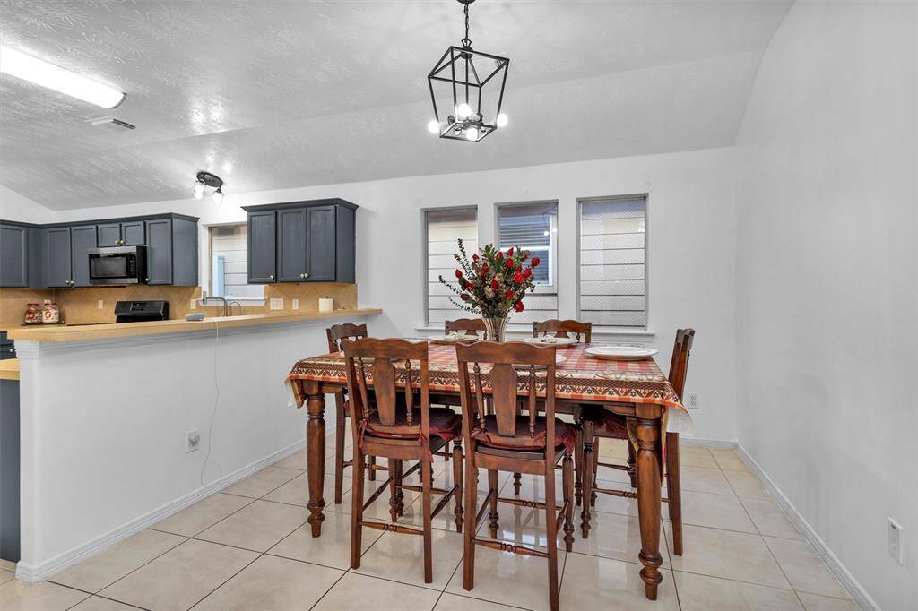 Bright and inviting dining area with elegant lighting, seamlessly connected to a modern kitchen. Perfect for entertaining and family gatherings.