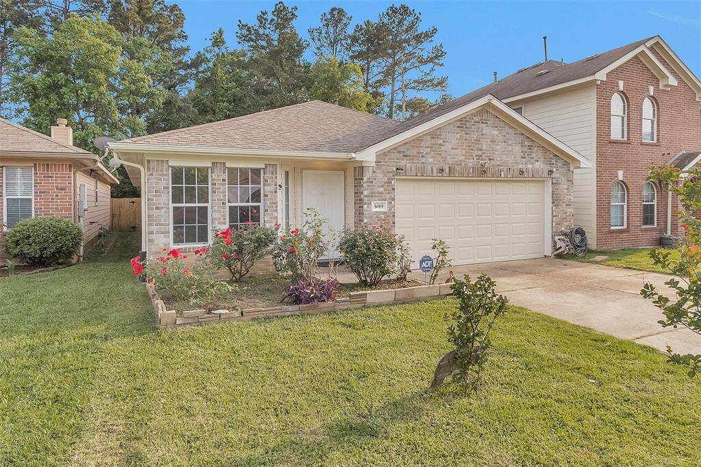 Charming single-story brick home with a two-car garage, featuring a well-maintained front yard with flower beds and a lush lawn. Located in a quiet neighborhood with mature trees offering a serene atmosphere.